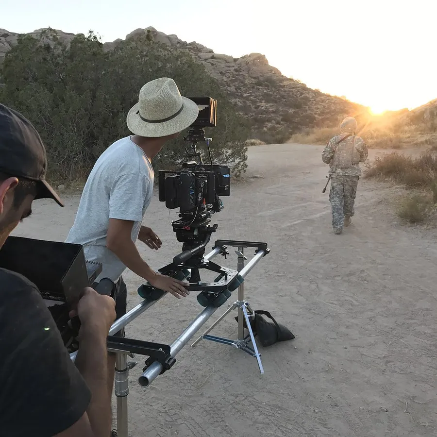 Camera operator framing a shot at sunset